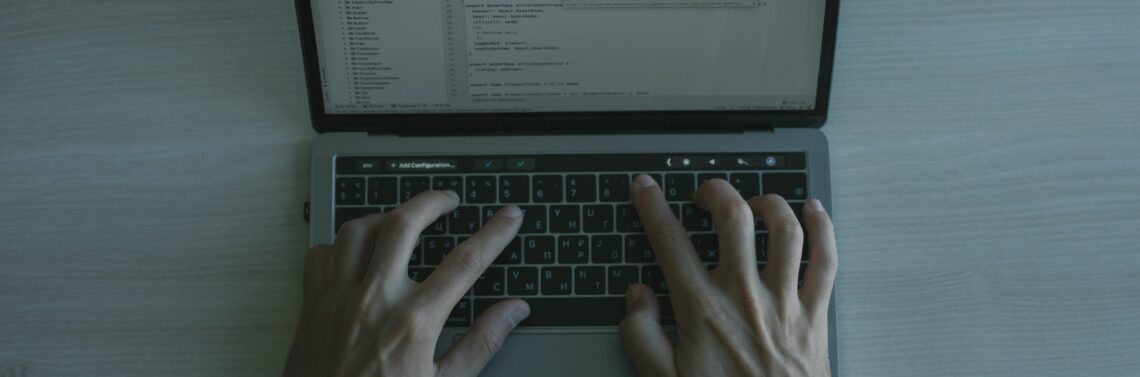 Man with hands on laptop keyboard providing cybersecurity services for businesses