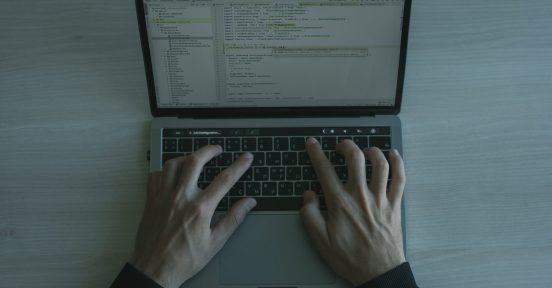 Man with hands on laptop keyboard providing cybersecurity services for businesses