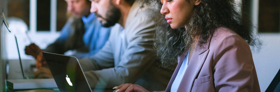 Equipo de trabajo mirando sus computadoras mientras calculan la percepción de IIBB