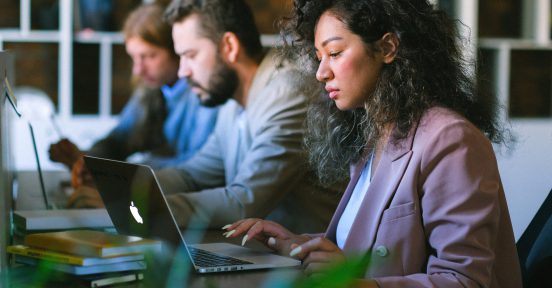 Equipo de trabajo mirando sus computadoras mientras calculan la percepción de IIBB