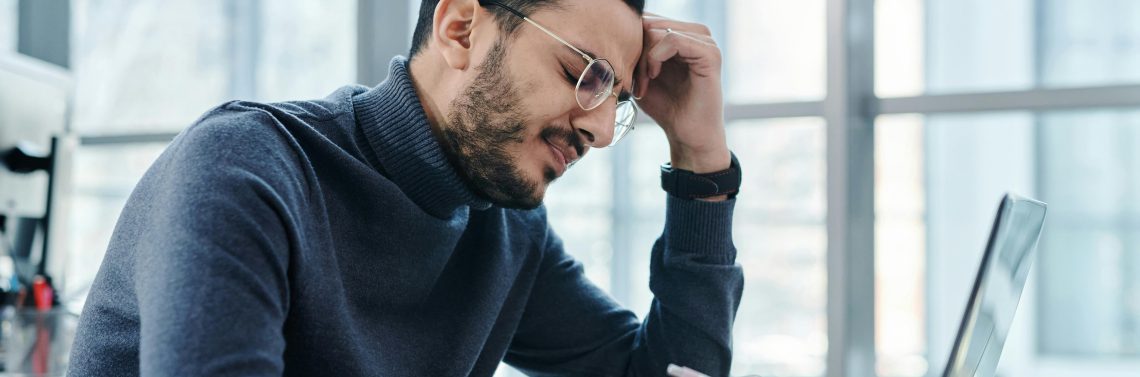 Men in front of a computer trying to use AI in cybersecurity for an enterprise.